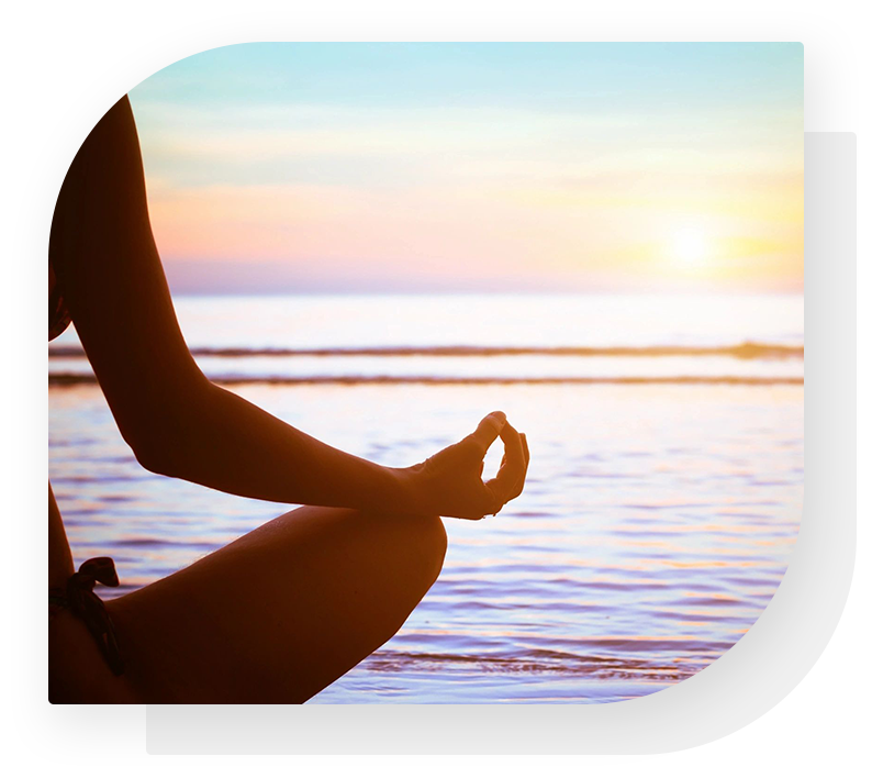 A person sitting in the lotus position on the beach